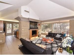 a living room with black furniture and a fireplace at Mid Century Modern Milwaukee House Spring Vacation in River Hills
