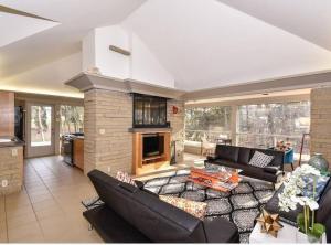 sala de estar con muebles negros y chimenea en Mid Century Modern Milwaukee House Spring Vacation, en River Hills