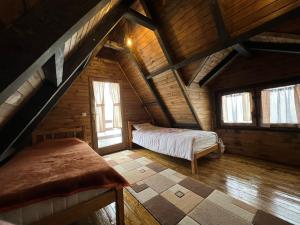a bedroom in a log cabin with a bed and windows at Vikendica Aview in Štrpce