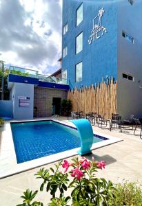 un hotel con piscina frente a un edificio en Porto Vila by AFT en Porto de Galinhas