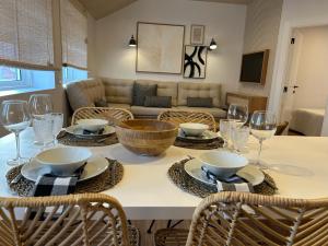 a dining room table with bowls and wine glasses at Casa das Manas in Nazaré