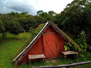 a small red house with a grass roof at mirador el paraíso in San José de Suaita