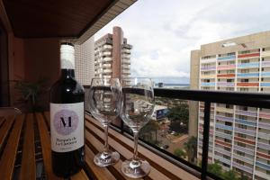een fles wijn en 2 wijnglazen op een balkon bij Flat Centro de Brasilia in Brasilia