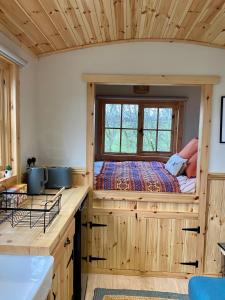 a bedroom with a bed in a wooden cabin at Lowgingerfield Shepherd Hut in Richmond