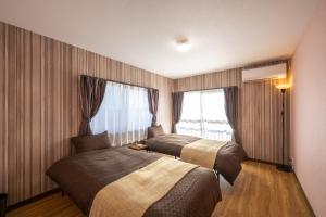 a hotel room with two beds and a window at VILLENT KUJUKURI MARINE in Kujukuri