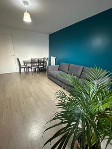 ein Wohnzimmer mit einem Sofa und einem Tisch in der Unterkunft Logement La courneuve-Aubervilliers RerB in La Courneuve
