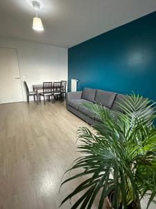 salon z kanapą i stołem w obiekcie Logement La courneuve-Aubervilliers RerB w mieście La Courneuve