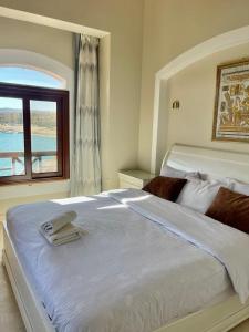 una camera da letto con un grande letto bianco e una finestra di Y 140 wast golf heated private pool a Hurghada