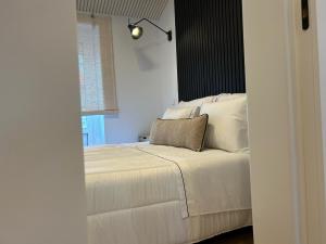 a bedroom with a white bed with a pillow on it at Casa das Manas in Nazaré +30 photos