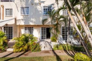 a house with two chairs and palm trees in front of it at Nuevo en Booking Casa Acapulco Diamante a Pasos de la Playa in Acapulco