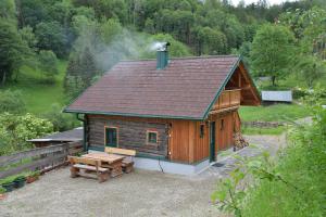 a log cabin with a bench and a smoke stack at Ferienhaus Schöberlhütte 