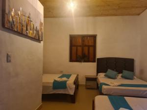 a room with two beds and a window at Hotel Alcázar Real in Utica