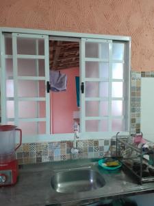 um balcão de cozinha com um lavatório e uma janela em Kitnet Rafael em São Thomé das Letras