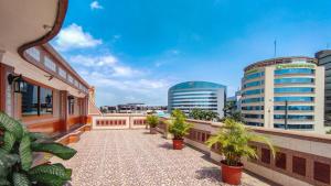 einen Balkon mit Topfpflanzen und Gebäuden in der Unterkunft Hotel Livingston Inn in Guayaquil