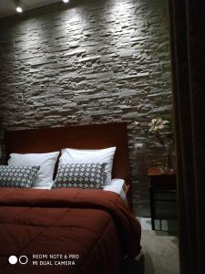 a bedroom with a bed with a stone wall at Chrysanty's tea house in Kalabaka