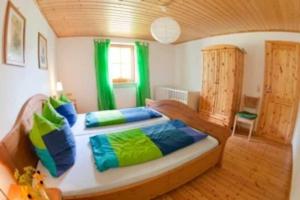 ein großes Bett in einem Zimmer mit grünen Vorhängen in der Unterkunft Ferienwohnungen Elsbacher Hof in Erbach
