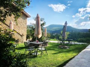 a table and chairs with umbrellas on the grass at Agriturismo Fonte Rosa in Fiastra