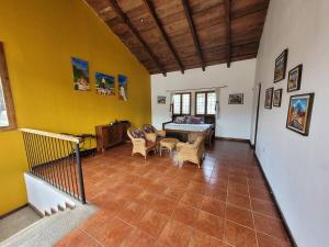 - un salon avec des murs jaunes, une table et des chaises dans l'établissement Amplia casa Antigua Guatemala con pérgola y jardín, à Antigua Guatemala