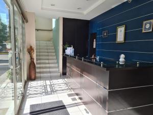 a lobby with a blue wall and a counter at Hotel Santa Fe in Paracho de Verduzco