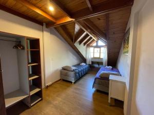 a attic room with two beds and a staircase at Departamentocasa zona centro in San Martín de los Andes