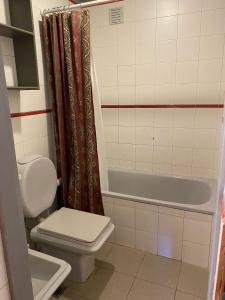 a bathroom with a toilet and a tub and a sink at Departamentocasa zona centro in San Martín de los Andes