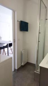 y baño con espejo, lavabo y mesa. en Super studio, proche centre ville en Rochefort