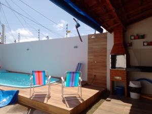 2 sillas sentadas en una terraza junto a una piscina en @vempraarembepe, en Camaçari