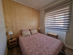 een slaapkamer met een bed met een paars dekbed en een raam bij Family Surf Home - Casa do Sol in Mafra