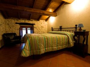 um quarto com uma cama e uma cadeira num quarto em La Casa Sù Le Dimore Del Borgo em Santo Stefano di Sessanio