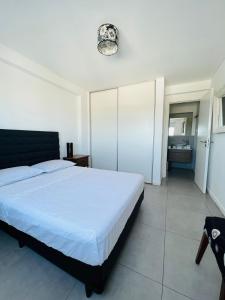 1 dormitorio con cama blanca y baño en DEPARTAMENTO AMOBLADO DE 1 DORMITORIO CON VISTA A LAS SIERRAS en Córdoba