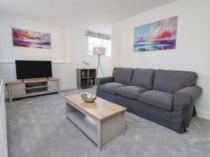 a living room with a couch and a tv at 1 Bishopgate Court in Goole