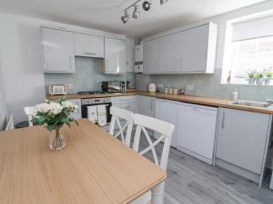 a kitchen with a wooden table and white cabinets at 1 Bishopgate Court in Goole