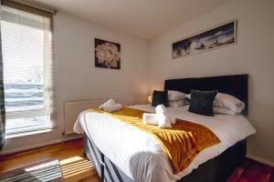 a bedroom with a large bed with two stuffed animals on it at Stunning 3 bed seaview apartment in Musselburgh