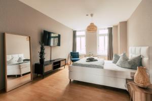 1 dormitorio con 1 cama grande y espejo en Luga Homes - Stadthaus en Leipzig