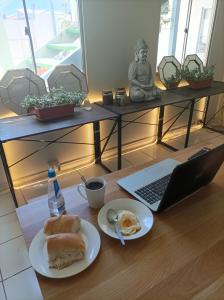 uma mesa com um prato de comida e um portátil em CasaLeon em Mejillones