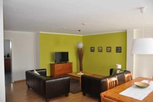 ein Wohnzimmer mit einem Tisch, Stühlen und einem TV in der Unterkunft Ferienwohnung Guddat in Hemsbach