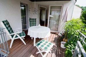 eine Terrasse mit einem Tisch und Stühlen auf einer Veranda in der Unterkunft Ferienwohnung Guddat in Hemsbach