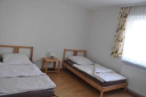 two twin beds in a room with a window at Ferienwohnung Guddat in Hemsbach