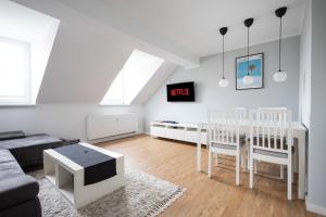 sala de estar blanca con mesa y TV en Ko-Living - urbanes Apartment am Zoo, en Giebichenstein