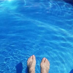 a person standing in the water with their feet in the water at Global Village Permaculture BnB in Oliver +8 photos