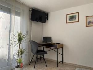 a desk with a laptop and a chair in a room at Ferienwohnung Haus Luzia in Düngenheim