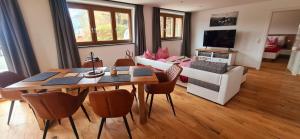 ein Wohnzimmer mit einem Tisch und einem Sofa in der Unterkunft Ferienwohnung mit Sauna am Alpsee in Bühl am Alpsee
