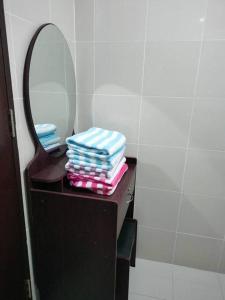 a stack of folded towels on a vanity with a mirror at Cubao Manhattanheights U24B TD in Manila