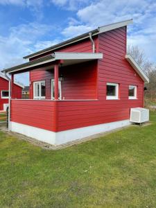 une maison rouge avec une dans l'établissement Vorbasse camping, à Vorbasse