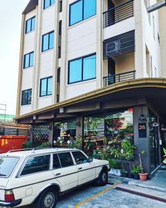 a white car parked in front of a building at 26bed and coffee in Ban Rong Khoei