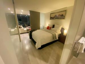 a bedroom with a bed and a living room at Modern, Clean, Luxury at the Right Price..... in Maribyrnong