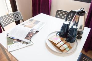 a table with a newspaper and a coffee pot and a magazine at 26bed and coffee in Ban Rong Khoei