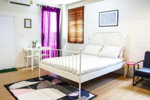 a bedroom with a bed and a table and a chair at 26bed and coffee in Ban Rong Khoei