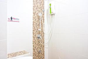 een badkamer met een douche en een tegelwand bij 26bed and coffee in Ban Rong Khoei
