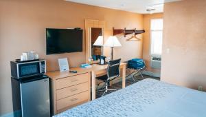 a hotel room with a bed and a desk with a television at Quiet Corner Inn in Brooklyn